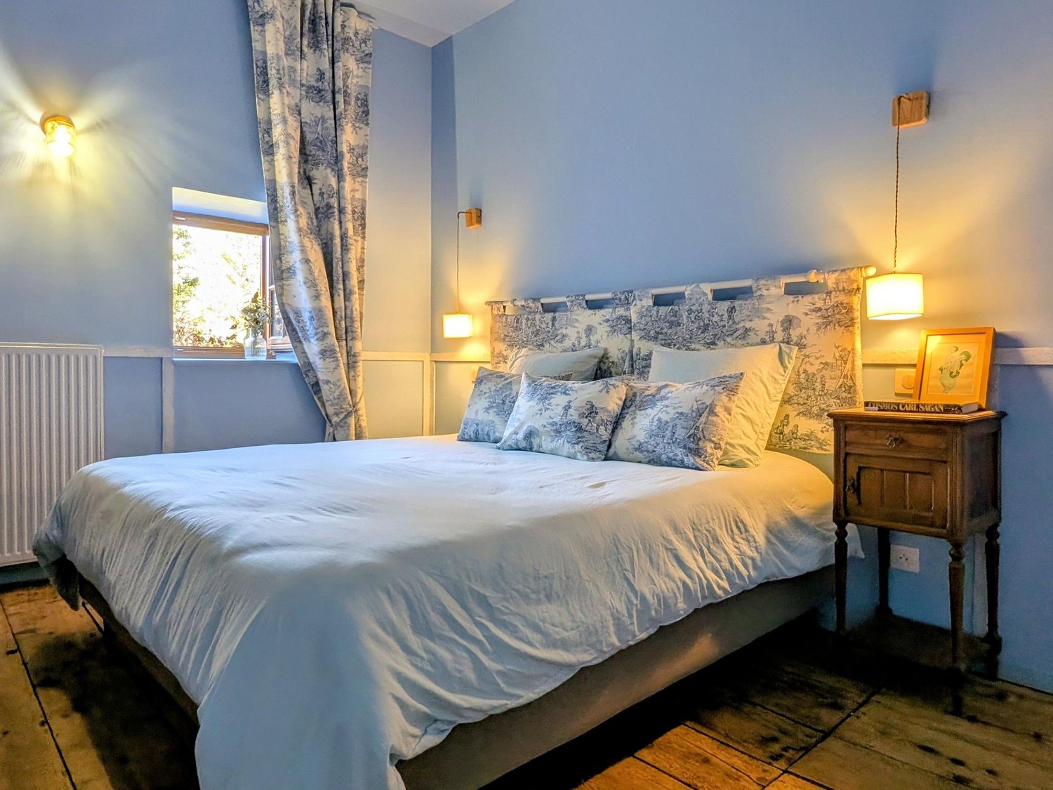 Une chambre du château, son lit double et sa fenêtre ouvrant sur le parc