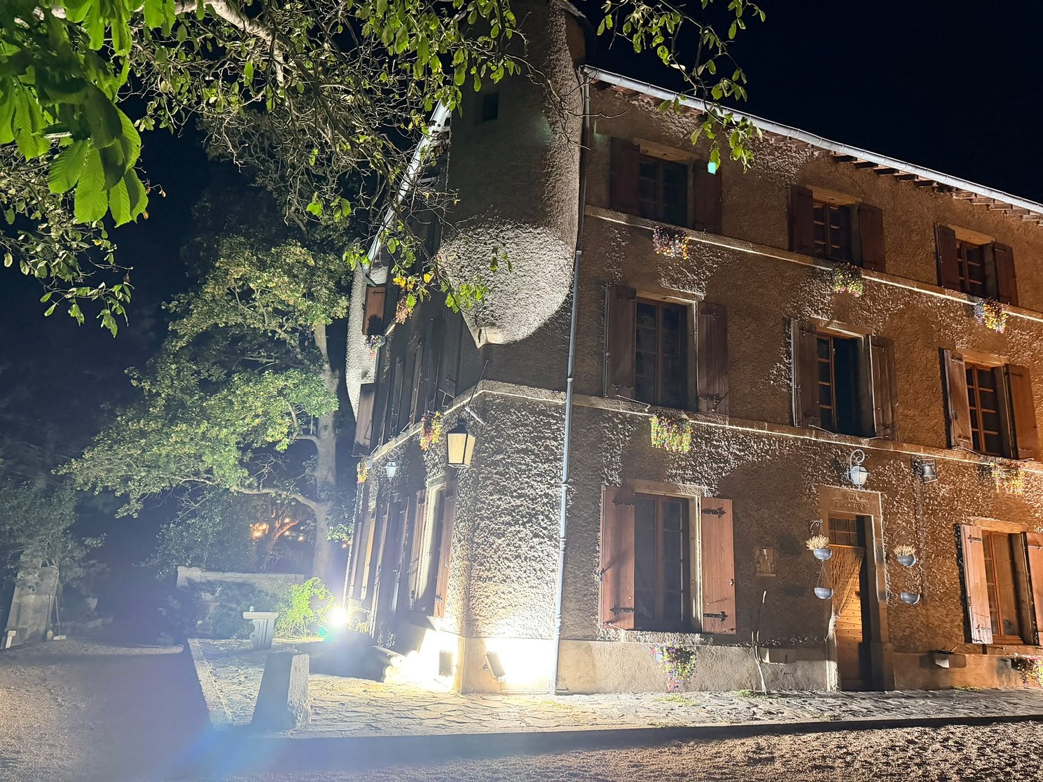 La façade du Château les Tourelles éclairée à la nuit tombée